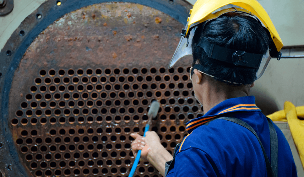 Boiler maintenance: Know when and how to do it - the image contains a man doing boiler maintenance